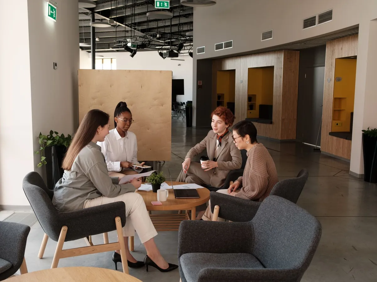 Groupe de professionnels échangeant dans l'espace détente d'un bureau moderne