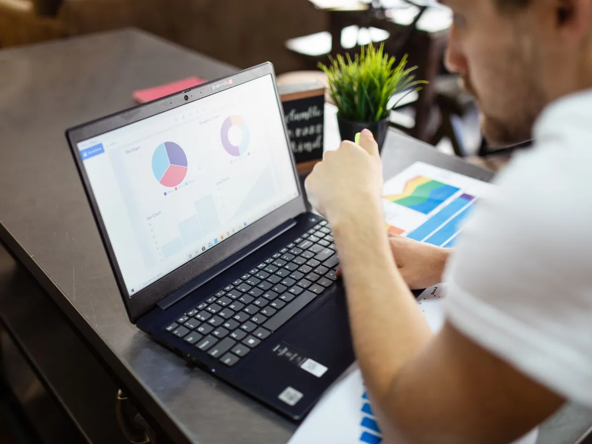 Homme examinant des graphiques sur son ordinateur portable pour une analyse commerciale