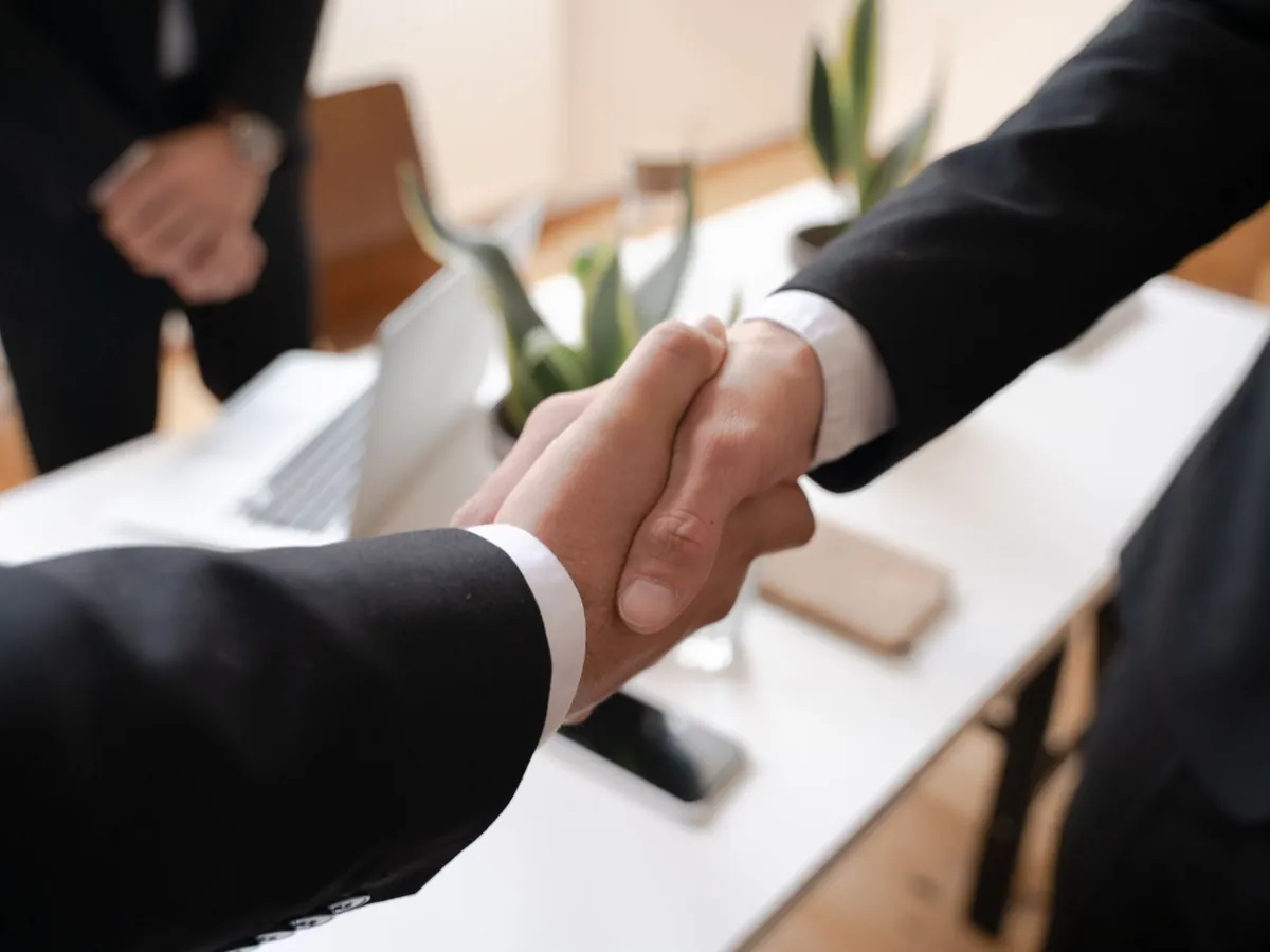 Gros plan sur une poignée de main entre deux professionnels, symbole d'un accord