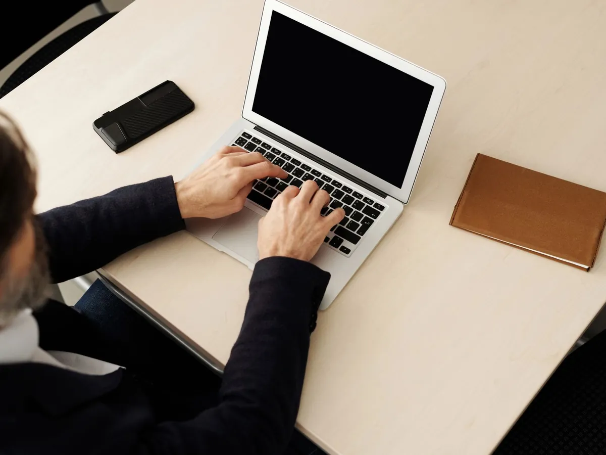 Homme d'affaires tapant sur son ordinateur portable à son bureau