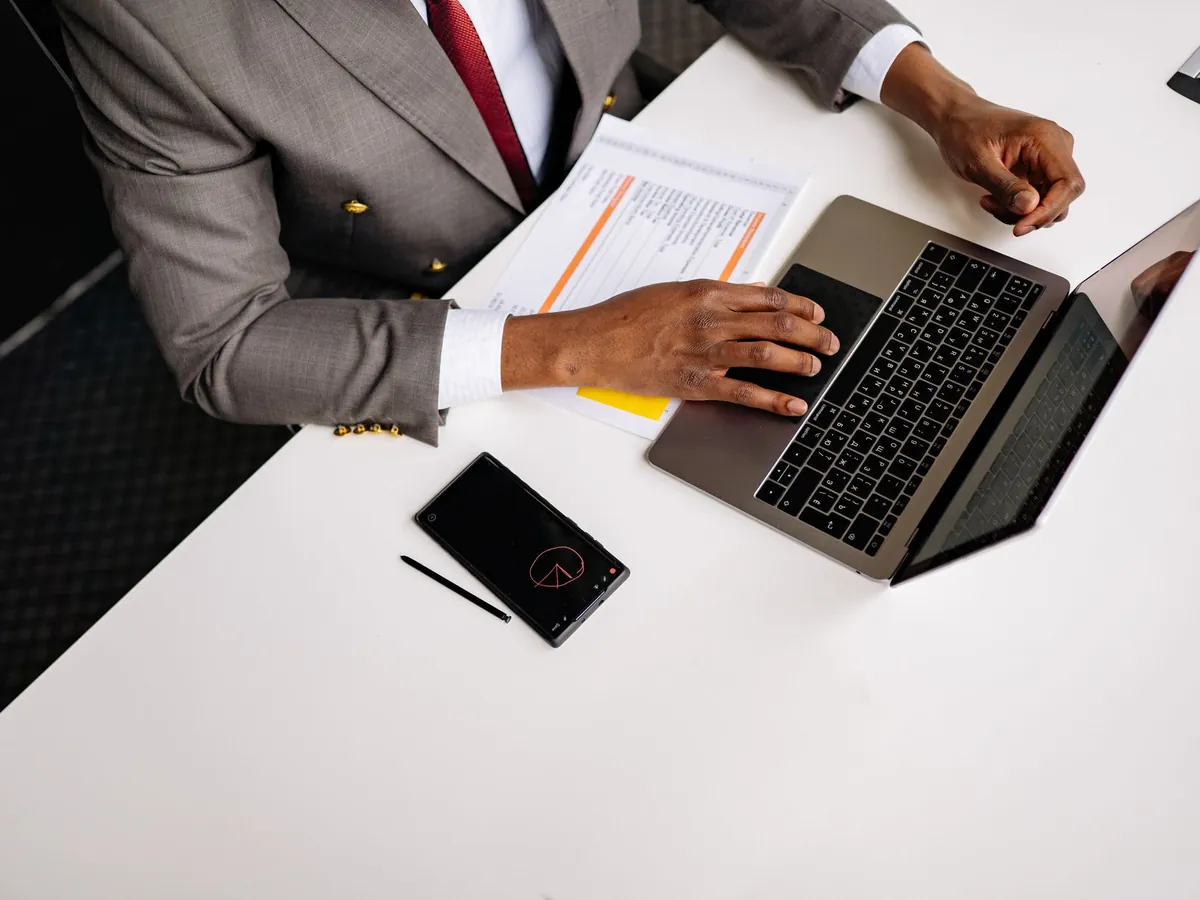 Professionnel en costume gris travaillant sur son ordinateur portable au bureau