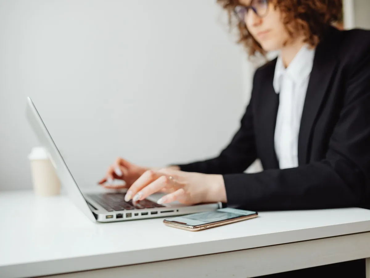 Femme d'affaires concentrée sur son ordinateur portable, à son bureau d'un espace moderne