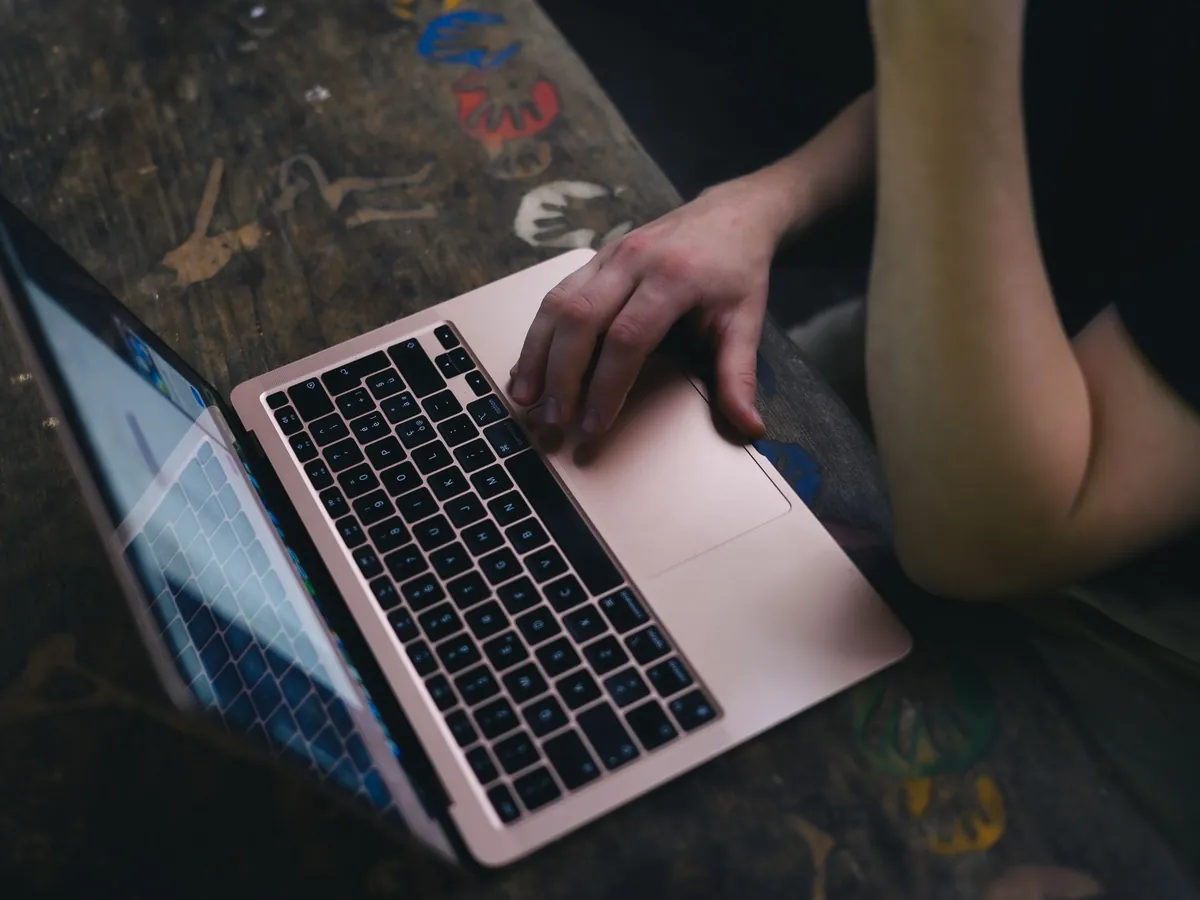Adulte utilisant un ordinateur portable sur un bureau en bois rustique