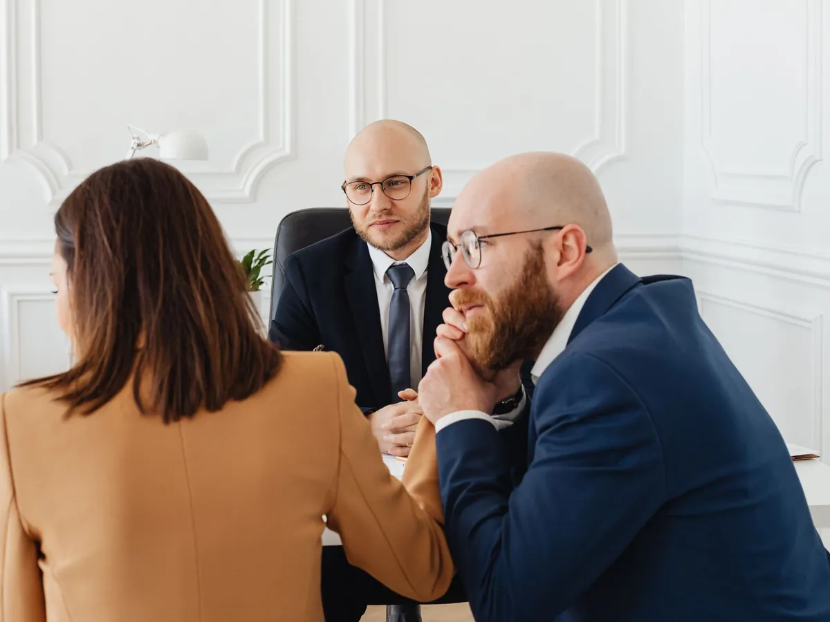 Avocats en consultation avec leurs clients dans un bureau moderne, autour de questions juridiques