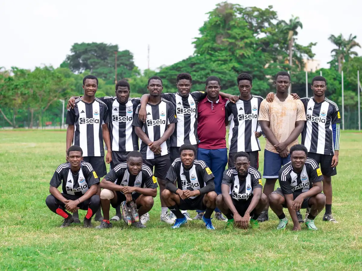 Équipe de football de jeunes en maillots noir et blanc, posant sur une pelouse