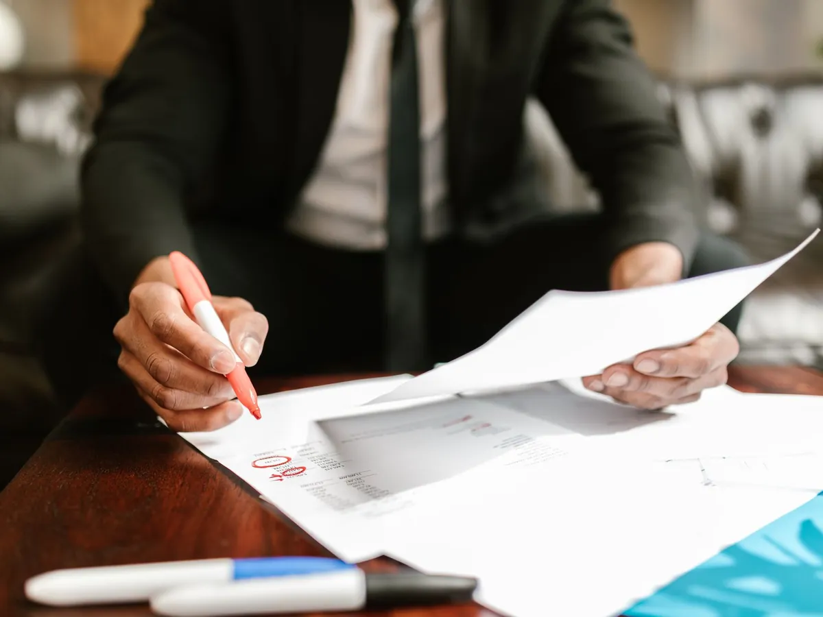 Homme d'affaires travaillant sur des documents financiers à son bureau, détails mis en évidence