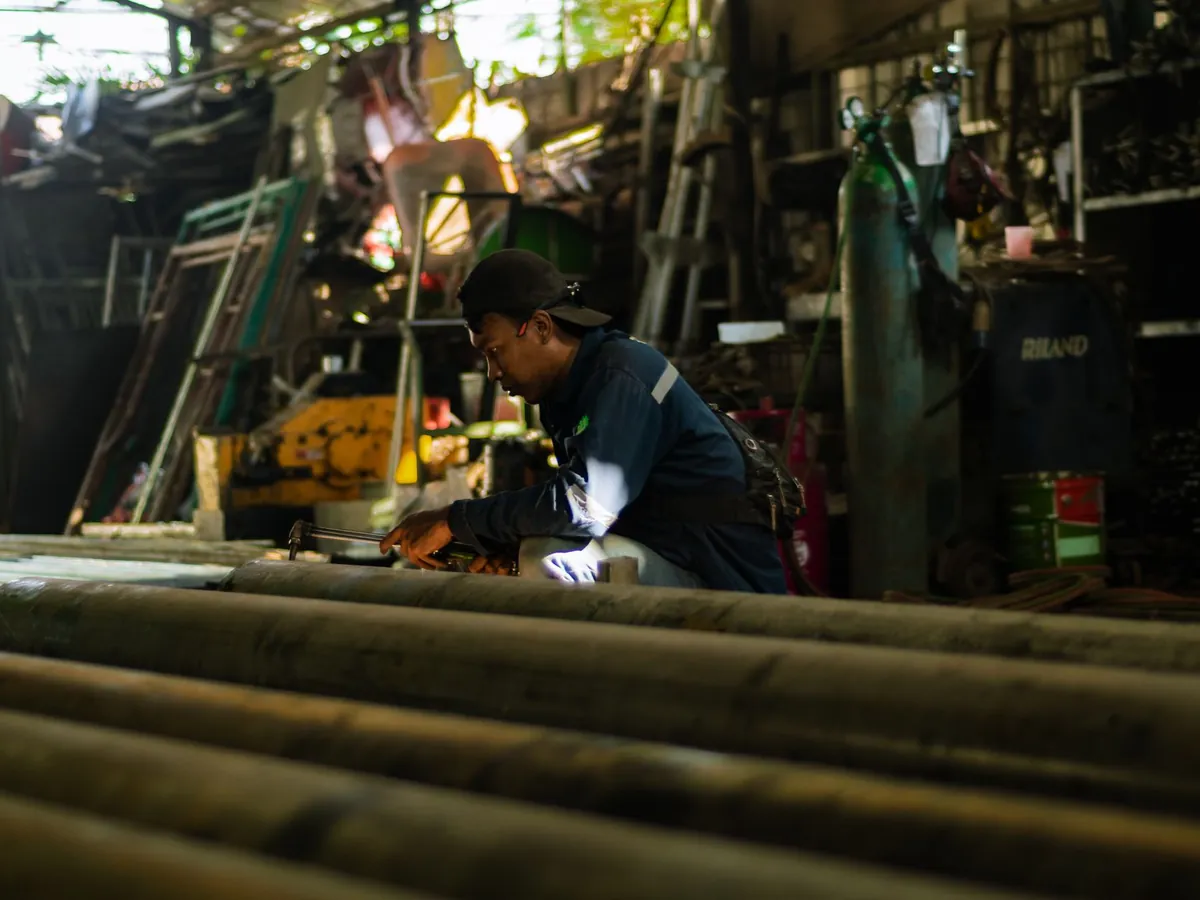 Artisan concentré au travail dans un atelier industriel animé, savoir-faire moderne