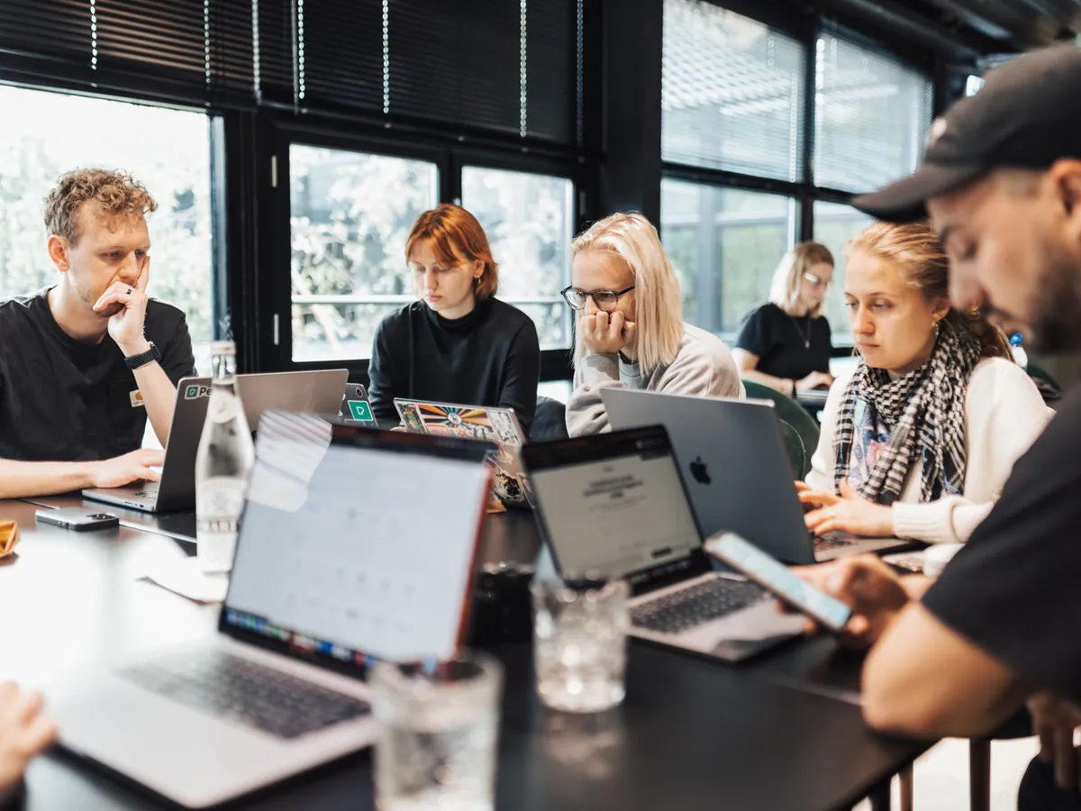 Groupe de professionnels travaillant sur ordinateurs portables et smartphones dans un bureau moderne