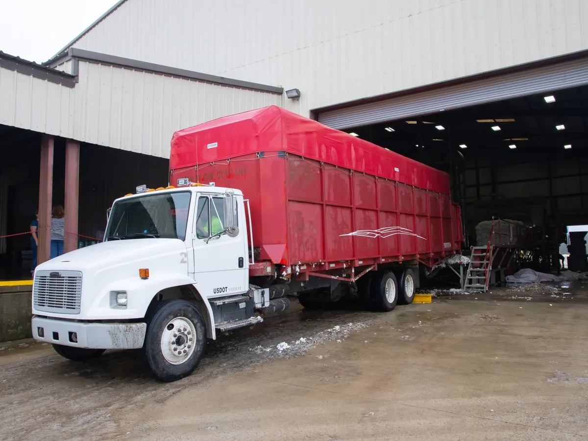 Camion remorque rouge à un quai de chargement d'entrepôt, prêt pour la livraison
