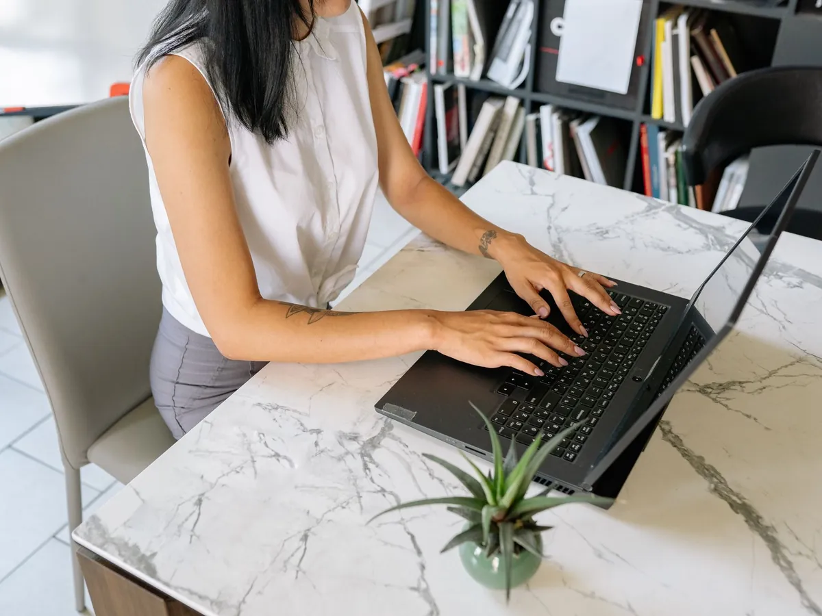 Professionnelle utilisant son ordinateur portable debout à son bureau