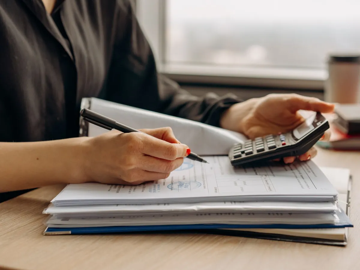 Gestionnaire annotant des documents comptables avec une calculatrice