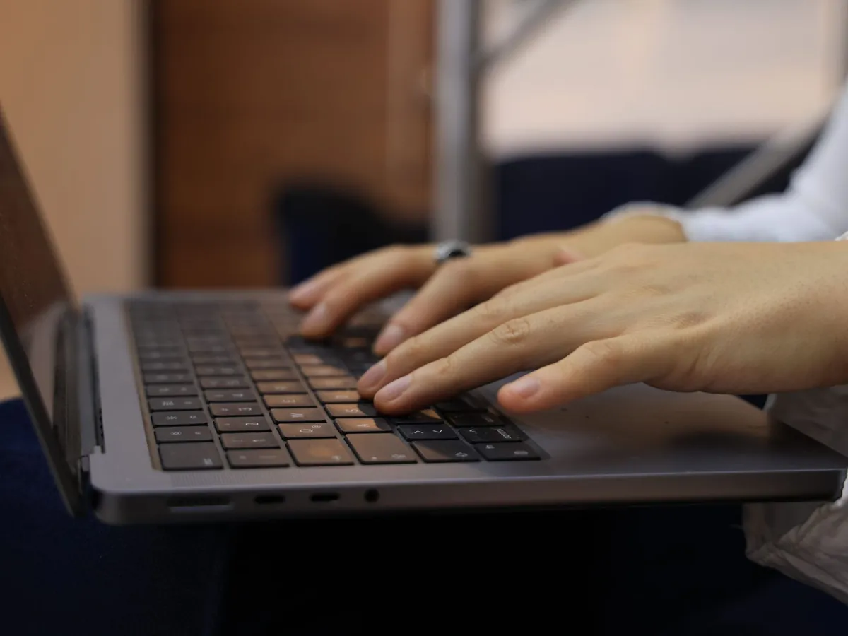 Mains posées sur le clavier d'un ordinateur portable