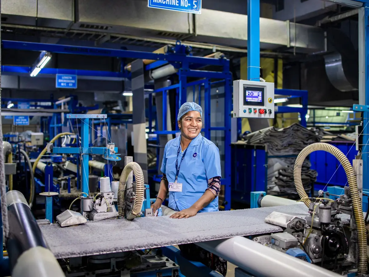 Opératrice souriante à son poste dans un atelier de production textile
