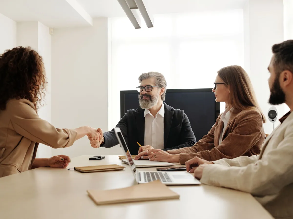Entretien de recrutement avec poignée de main autour d'une table de réunion