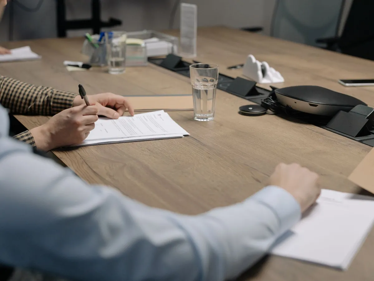 Réunion d'affaires professionnelle, des personnes signent des documents sur une table de conférence