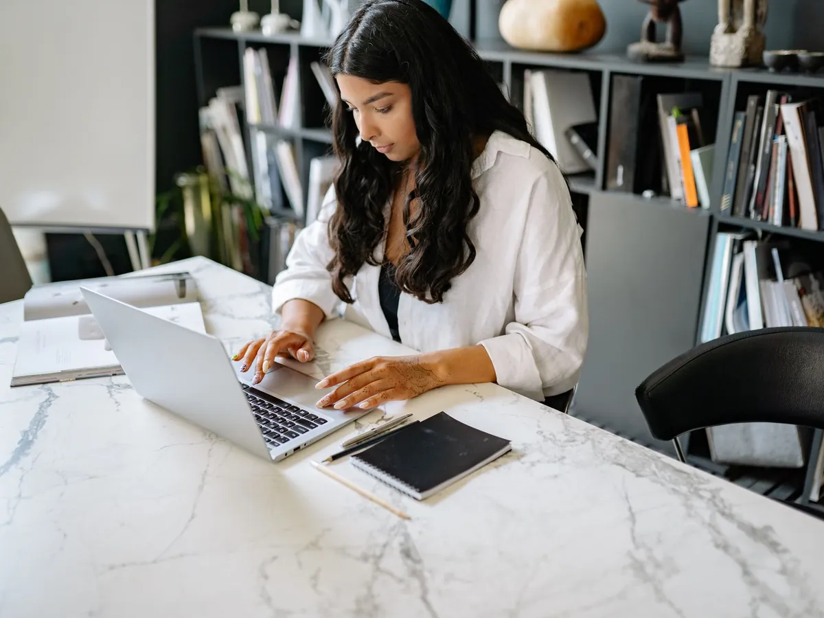 Femme d'affaires confiante travaillant sur son ordinateur portable dans un bureau moderne