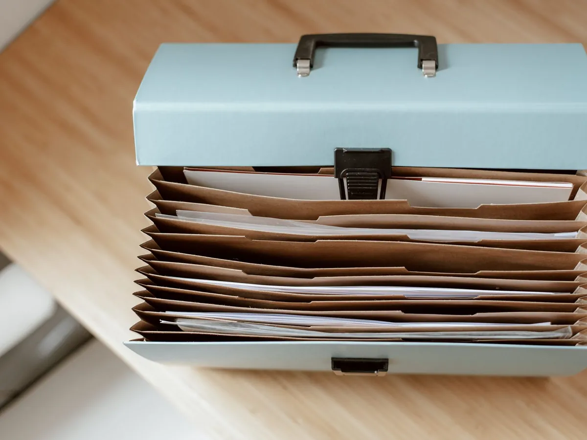 Vue de dessus d'une serviette avec des documents posés sur une table en bois, en journée