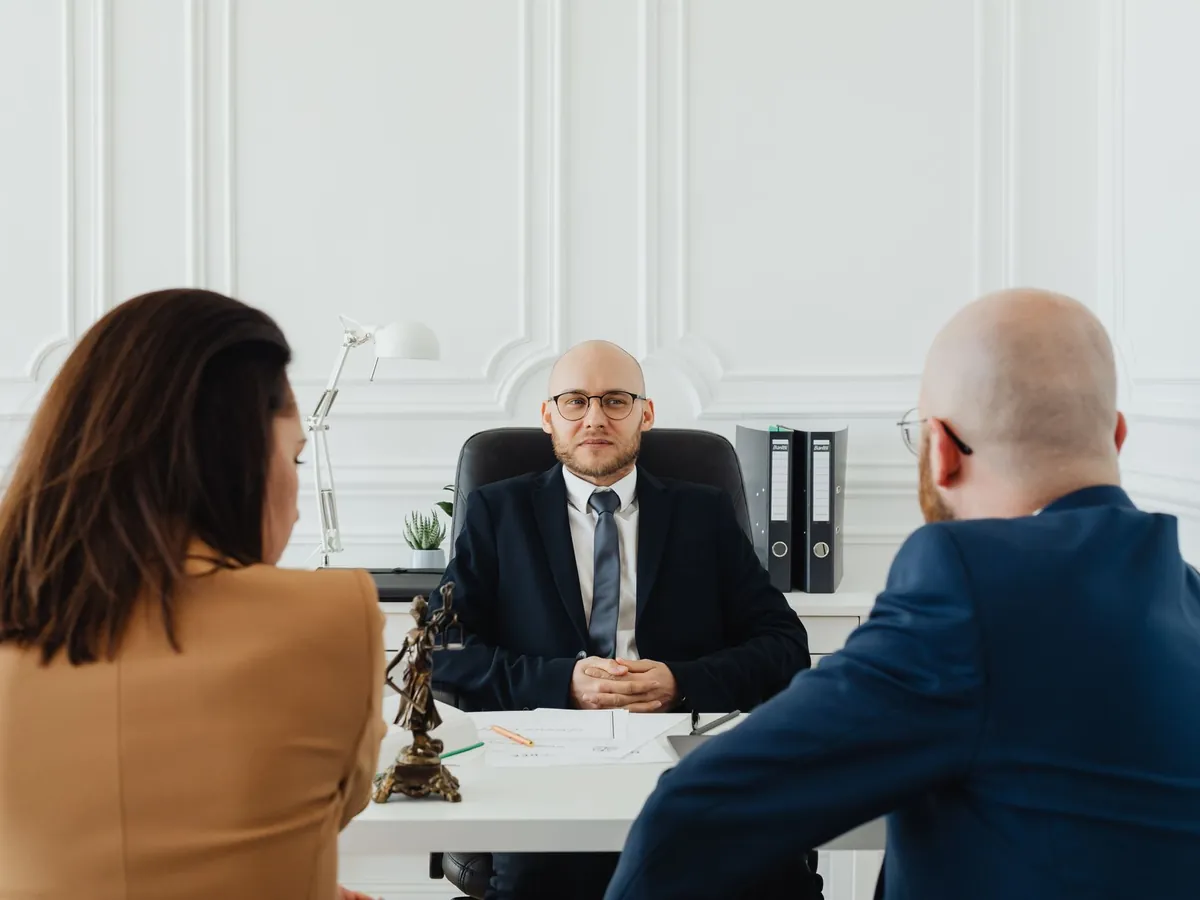 Avocat recevant ses clients dans un bureau formel, pour une consultation juridique