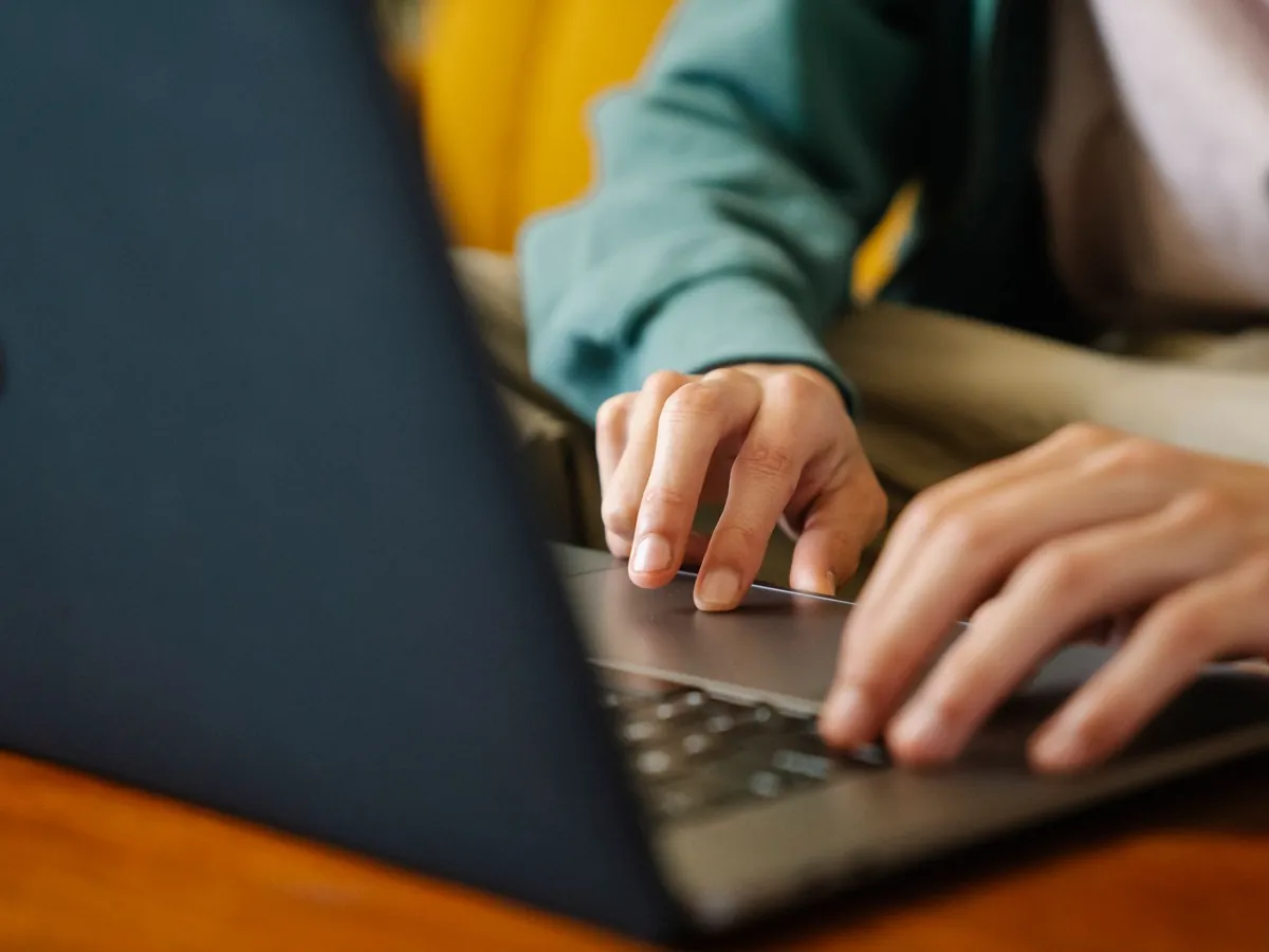 Employé anonyme surfant sur internet avec un netbook tout en travaillant sur un projet à son bureau