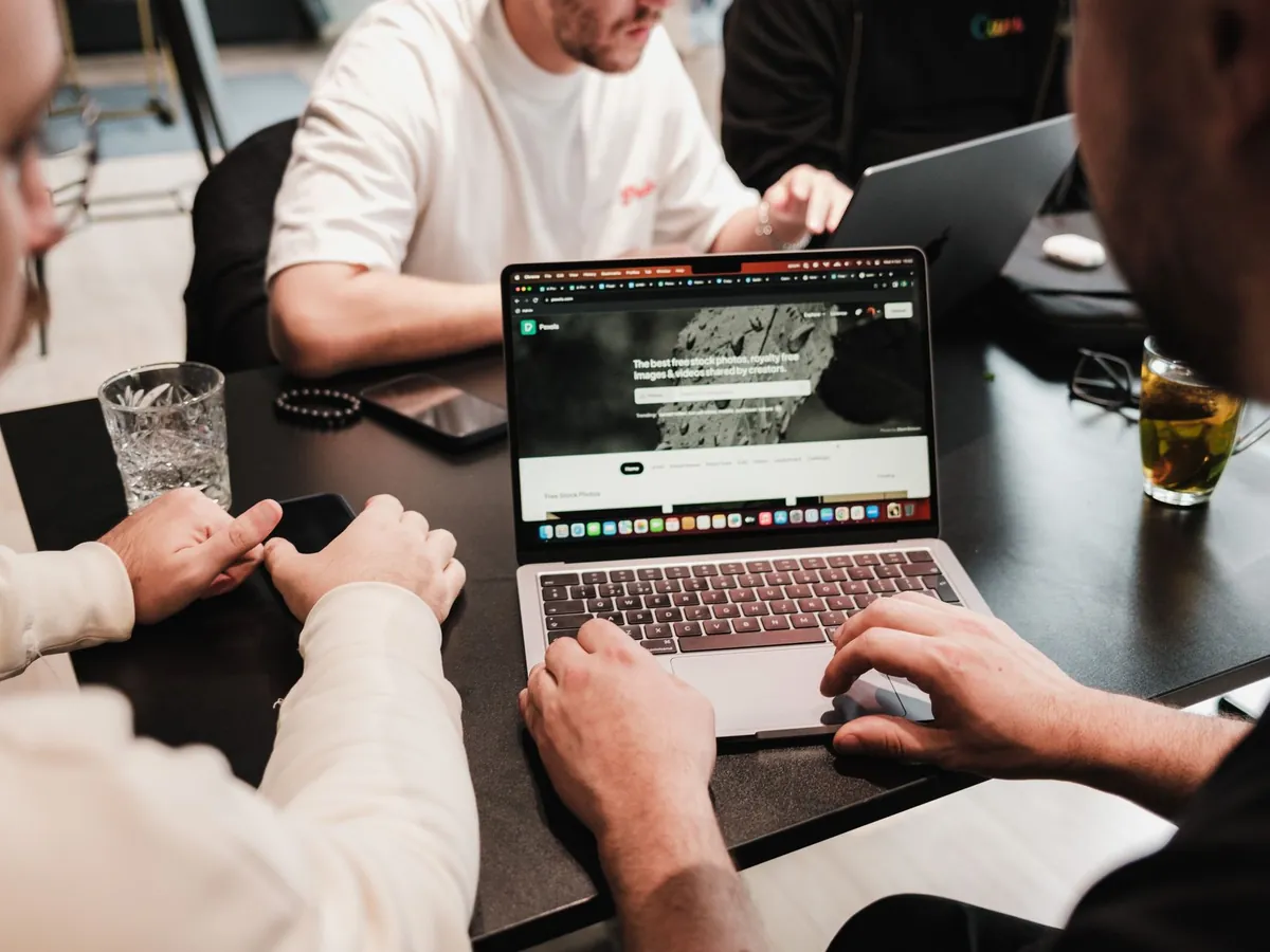 Collègues travaillant ensemble sur ordinateurs portables autour d'une table moderne