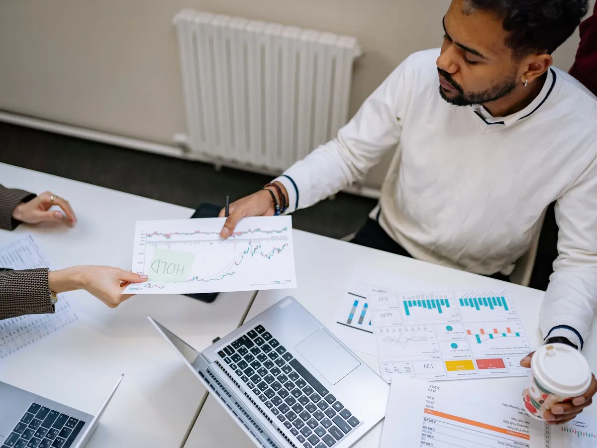 Collègues travaillant ensemble sur des graphiques et des données financières, en réunion