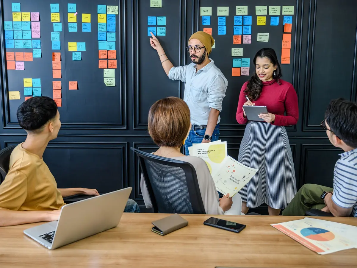 Équipe réunie en intérieur utilisant des post-it pour réfléchir et discuter des idées de projet