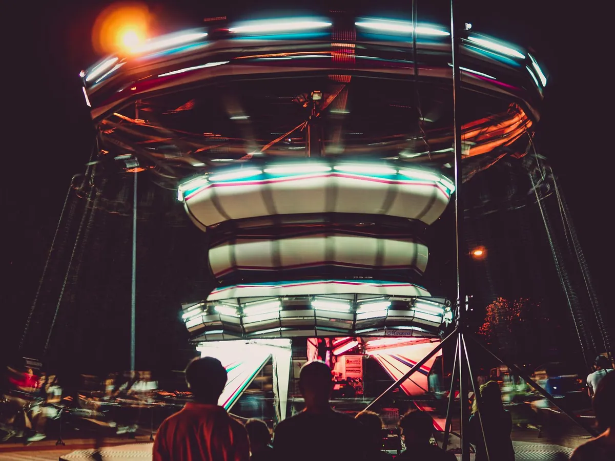 Manège coloré et dynamique la nuit, avec un effet de flou de mouvement et des lumières vives