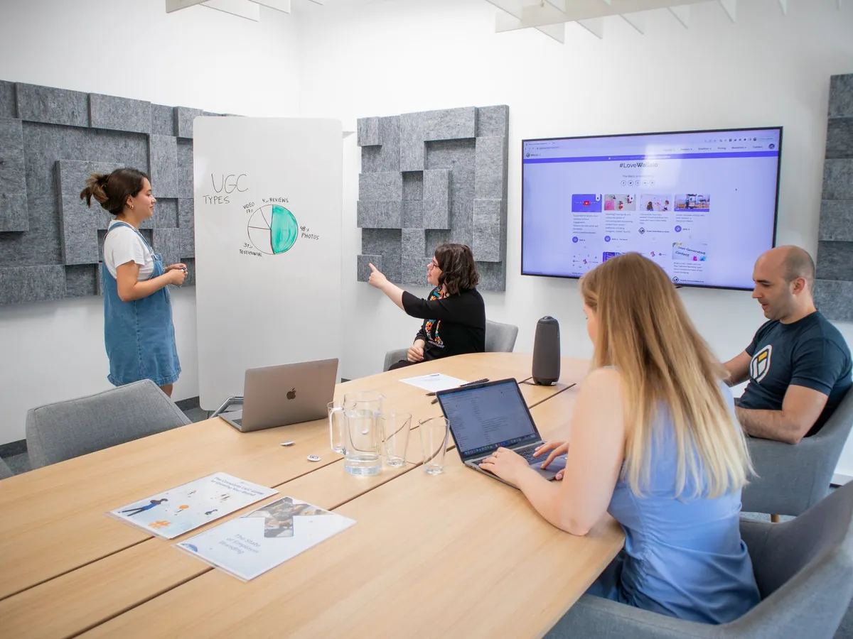Groupe de professionnels en réunion d'équipe, avec présentation, dans un bureau moderne