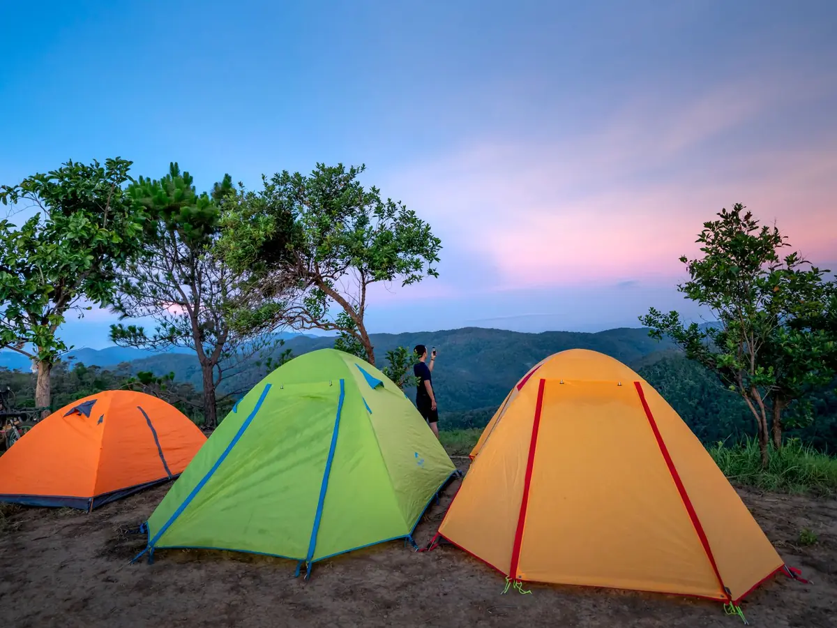 Tentes colorées sur un terrain de camping au coucher du soleil