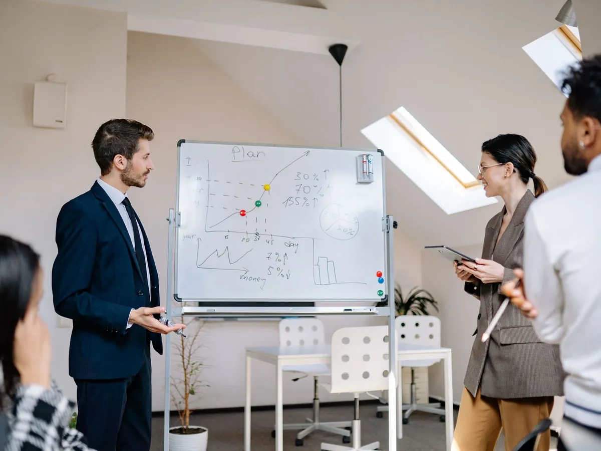 Consultants réunis autour d'un tableau blanc lors d'un atelier de travail