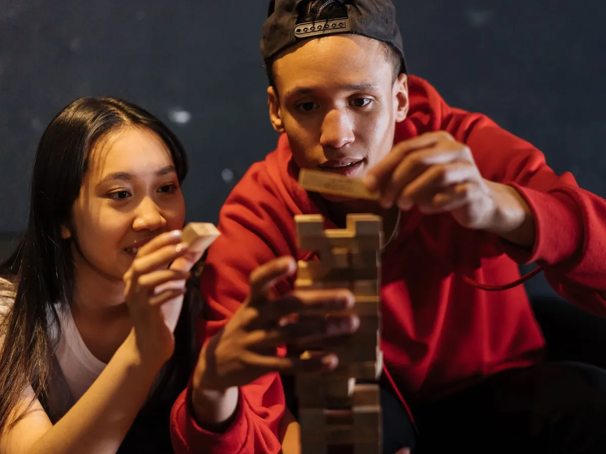 Deux amis construisant une tour en bois lors d'un jeu en équipe