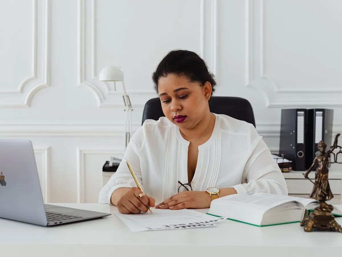 Notaire à son bureau avec un ordinateur portable et une statuette de la justice