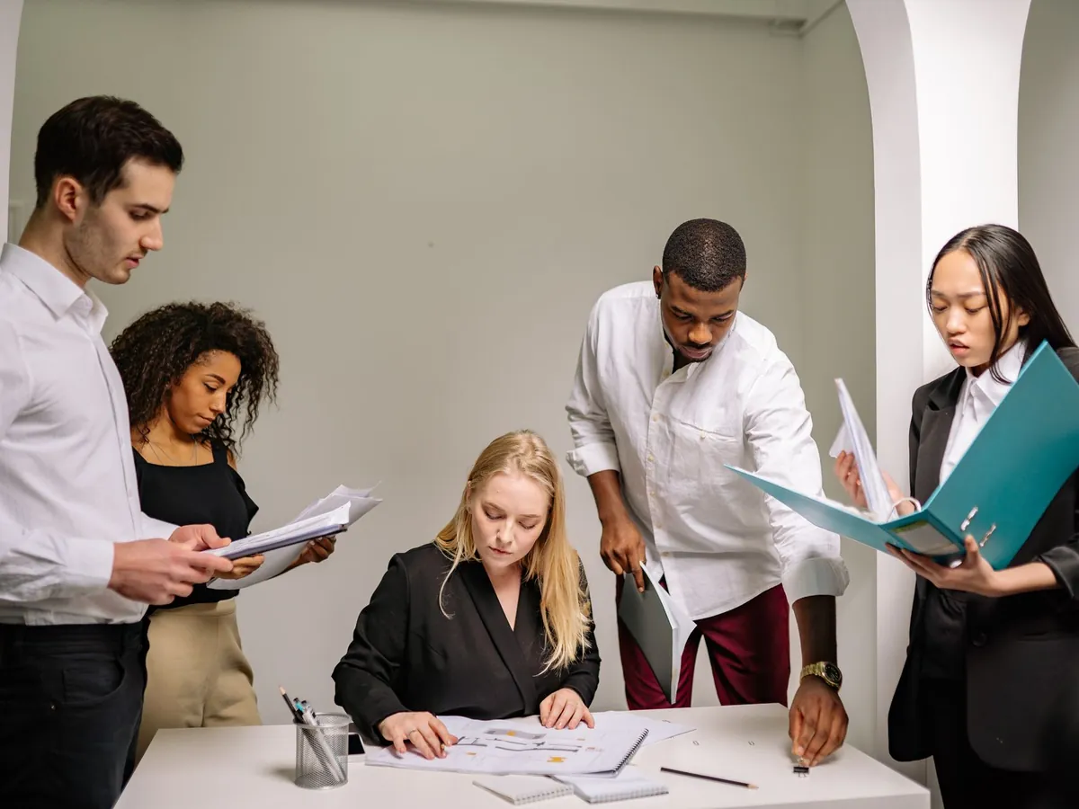 Équipe diversifiée travaillant ensemble au bureau, examinant des documents sur des projets