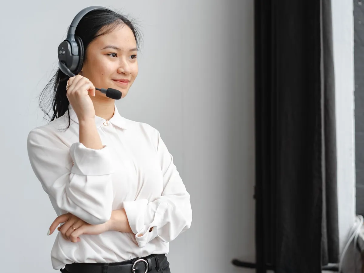 Femme asiatique professionnelle avec casque assurant le support client dans un bureau