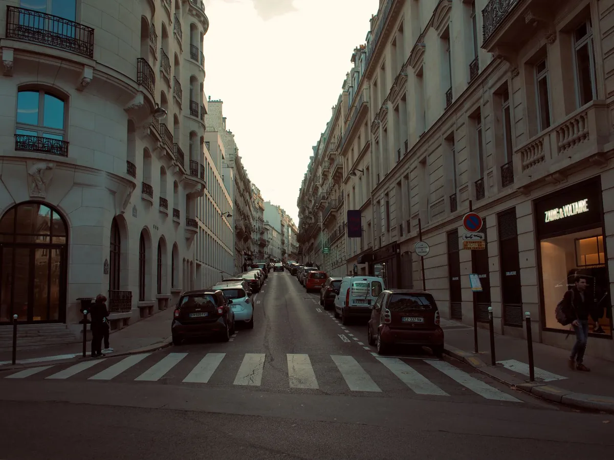 Rue européenne pittoresque bordée d'architecture classique et de voitures garées