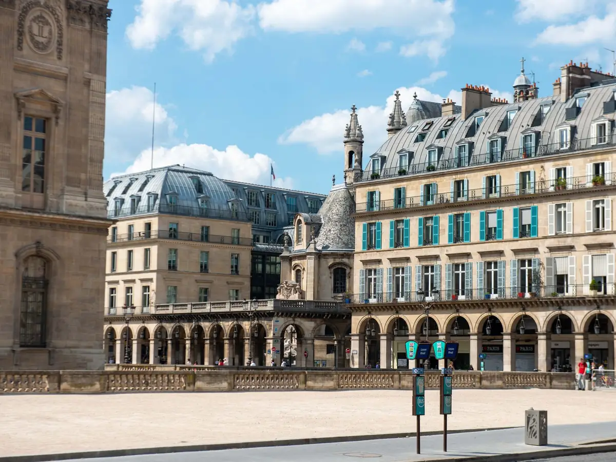 Vue classique d'une rue parisienne avec des bâtiments ornés et un ciel dégagé