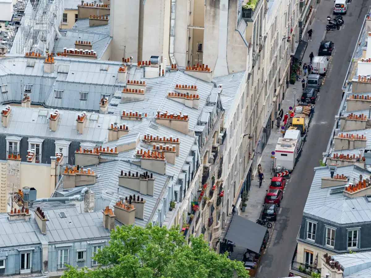 Vue plongeante et captivante sur les toits et les rues de Paris, illustrant l'architecture urbaine